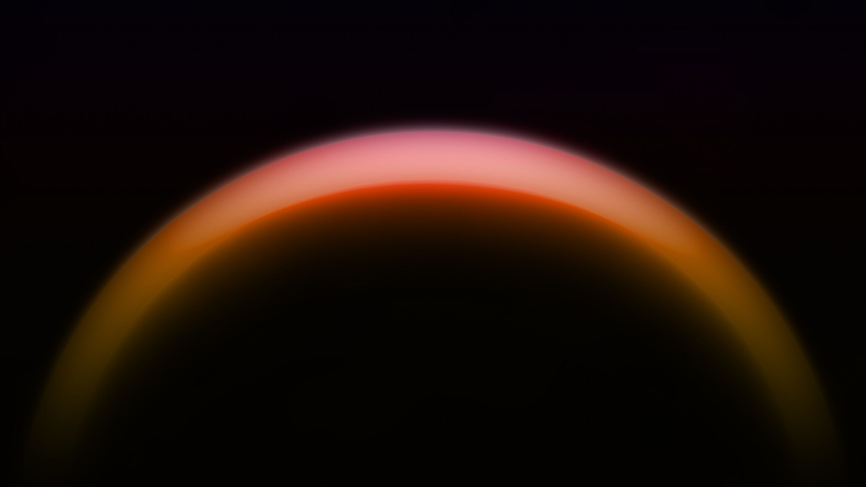 Glowing crescent of a dark planet's atmosphere against black space, with layered pink, orange and red haze